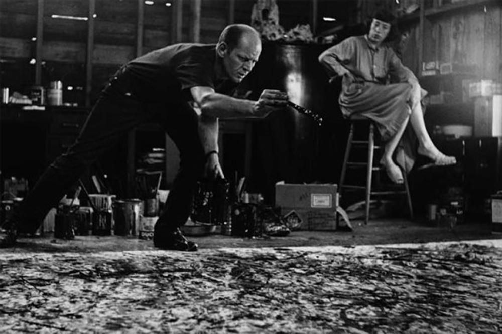 Pollock at work, with Less Krasner behind. Photo by Martha Holmes for LIFE, 1949.